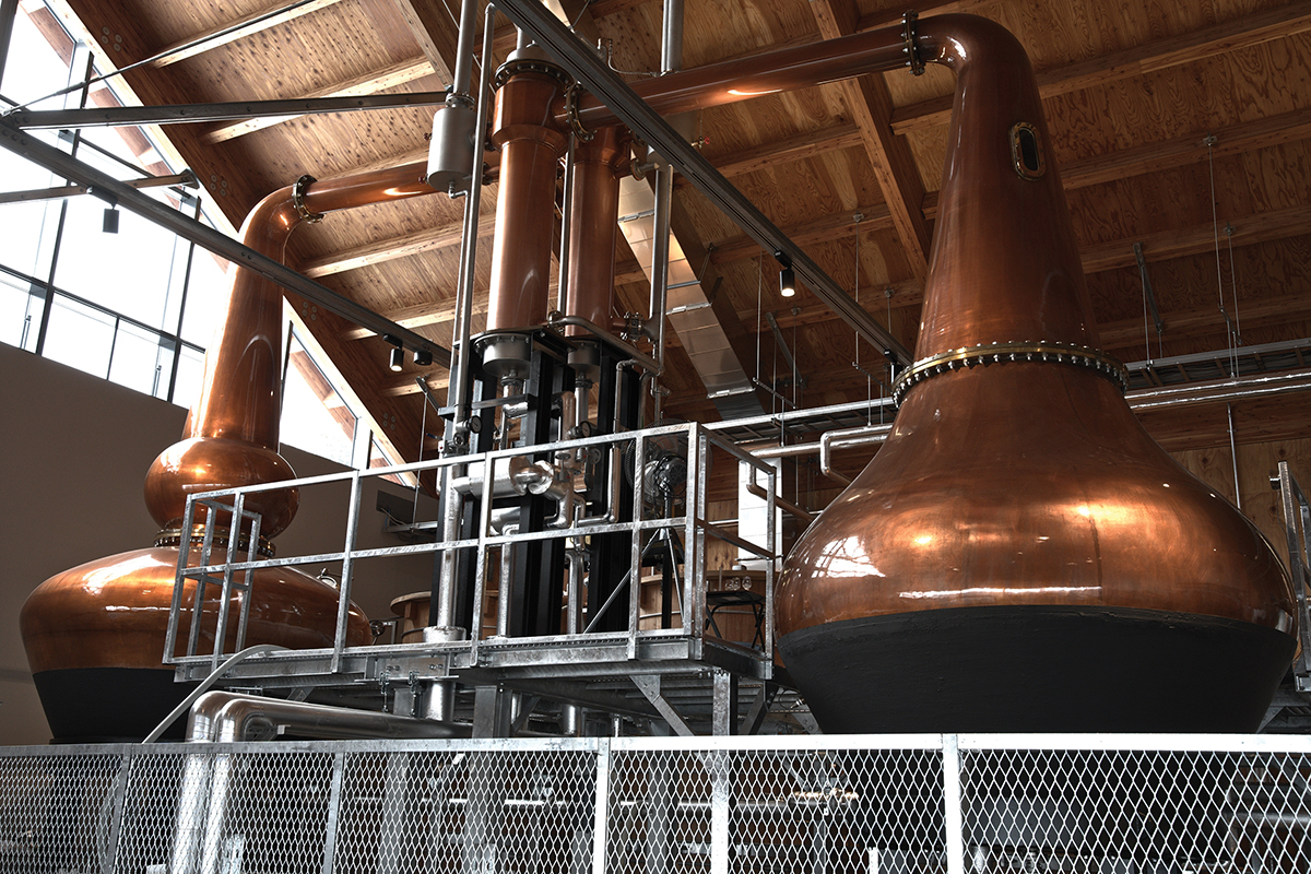 Copper stills at a whiskey distillery refine and concentrate the fermented liquid for spirit production.