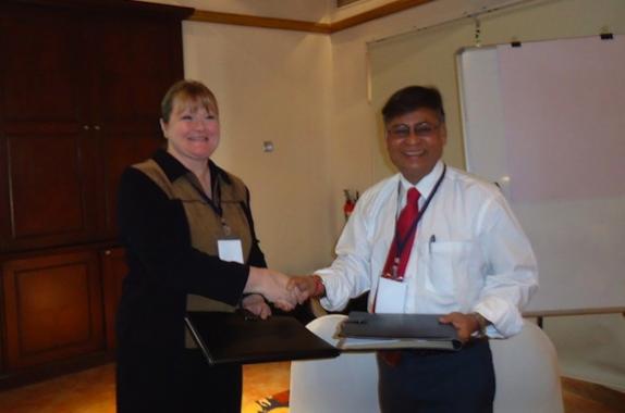 Shri Hirak Dutta and Ms. Louisa Nara exchanging the signed MOU folders.