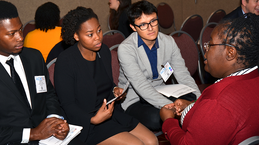 Kathy Lee (right) speaks with chemical engineering students at an industry event.